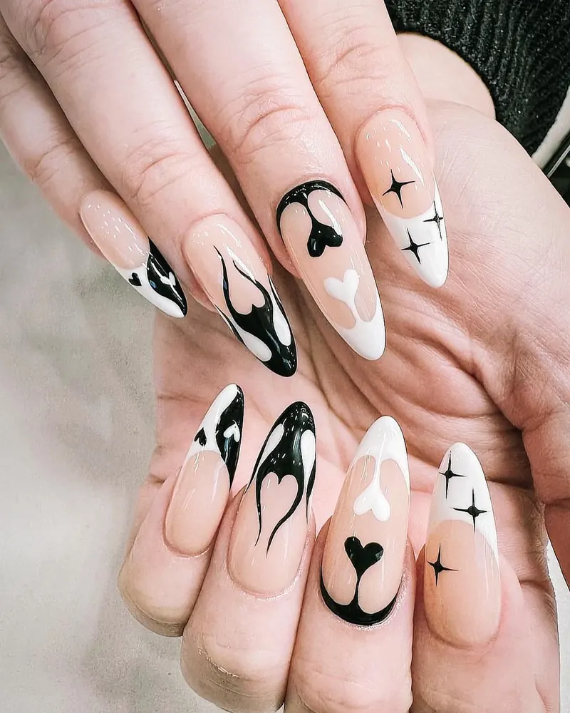 Nude almond nails with hand-painted black gothic flames, hearts and stars