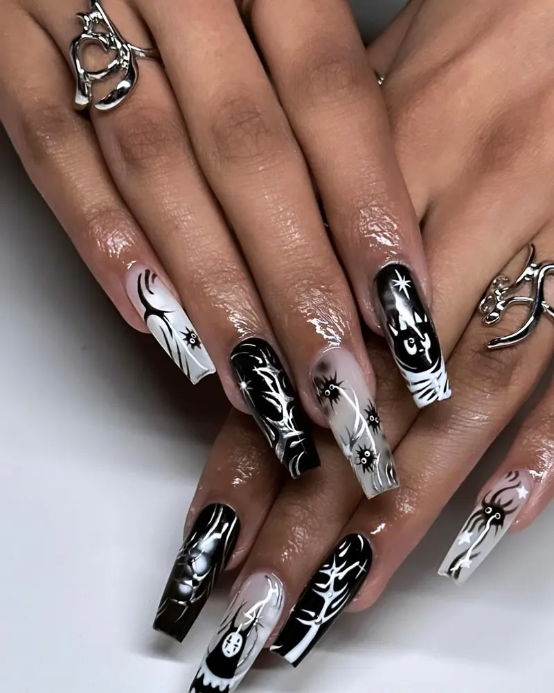 Black and white coffin nails with spiders, a skeleton and spirit-face art