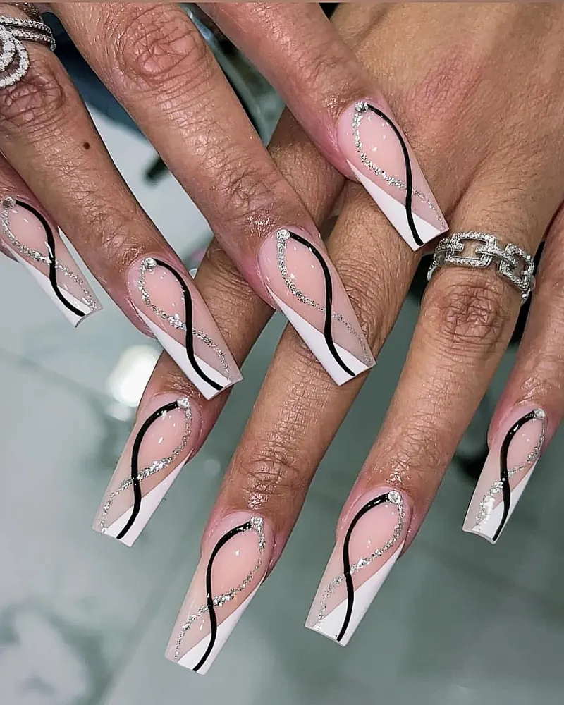 Nude coffin nails with white French tips and black and silver glitter swirl lines