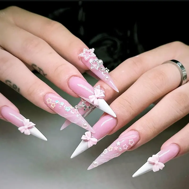 Soft pink stiletto nails with white tips, 3D bows and star decals