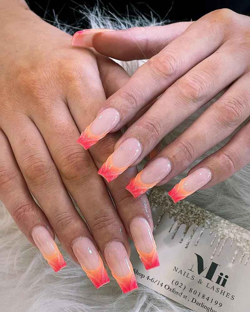 Nude coffin nails with orange-red sunset ombré French tips